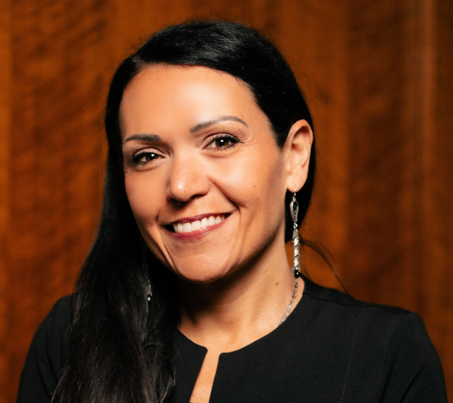 Dr. Rheanna Robinson. She has long, black hair and a tan complexion with a black shirt on.