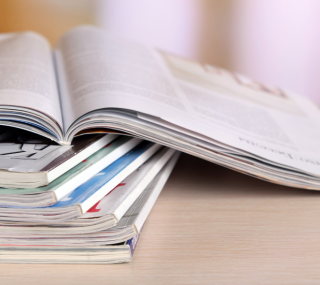 A stack of publications with the top journal left open.  