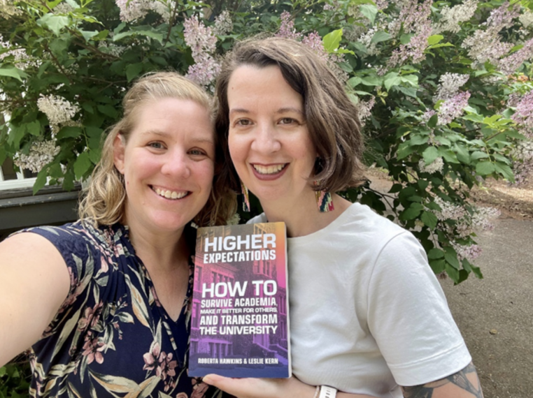Selfie of Leslie Kern and Roberta Hawkins holding their book "Higher Expectations: How to Survive Academia, Make It Better for Others, and Transform the University ."