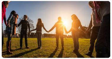 Multiracial group of young people holding hands in a circle